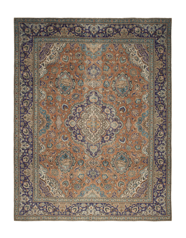 Oversized Persian-style wool and cotton rug in orange and navy with intricate floral patterns and traditional motifs.