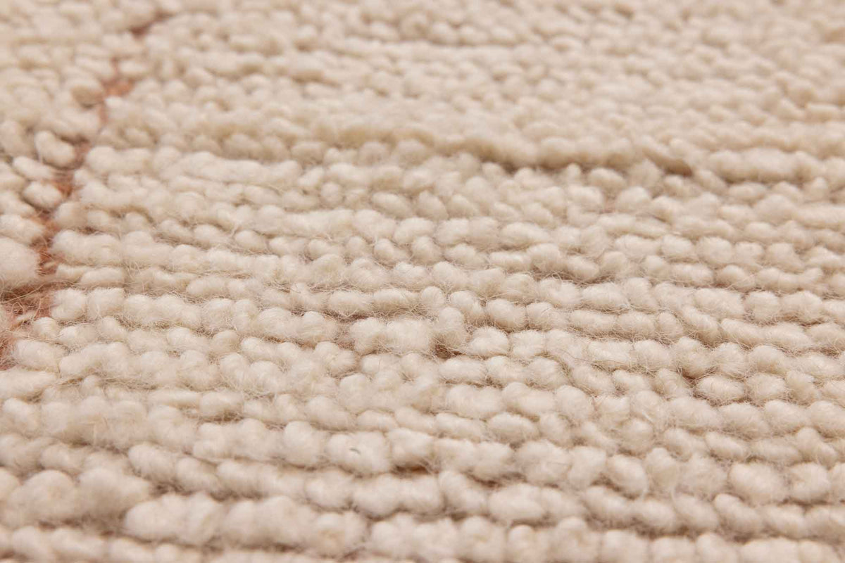 Close-up of a soft, apricot-colored shaggy wool rug featuring a thick, handwoven high-pile texture.
