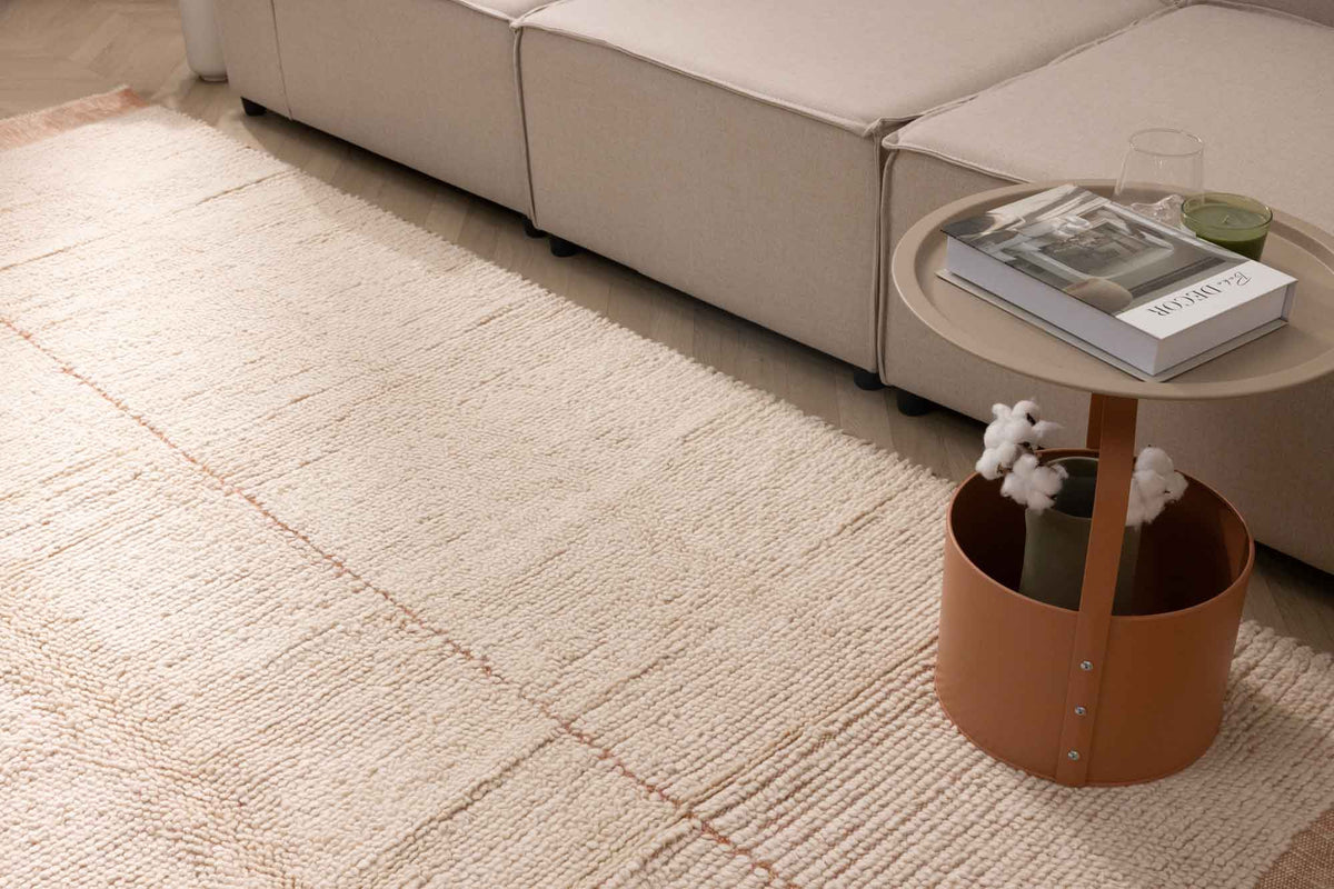 Apricot shaggy wool rug with a thick, textured pile and subtle grid pattern, placed in a cozy living room setting.