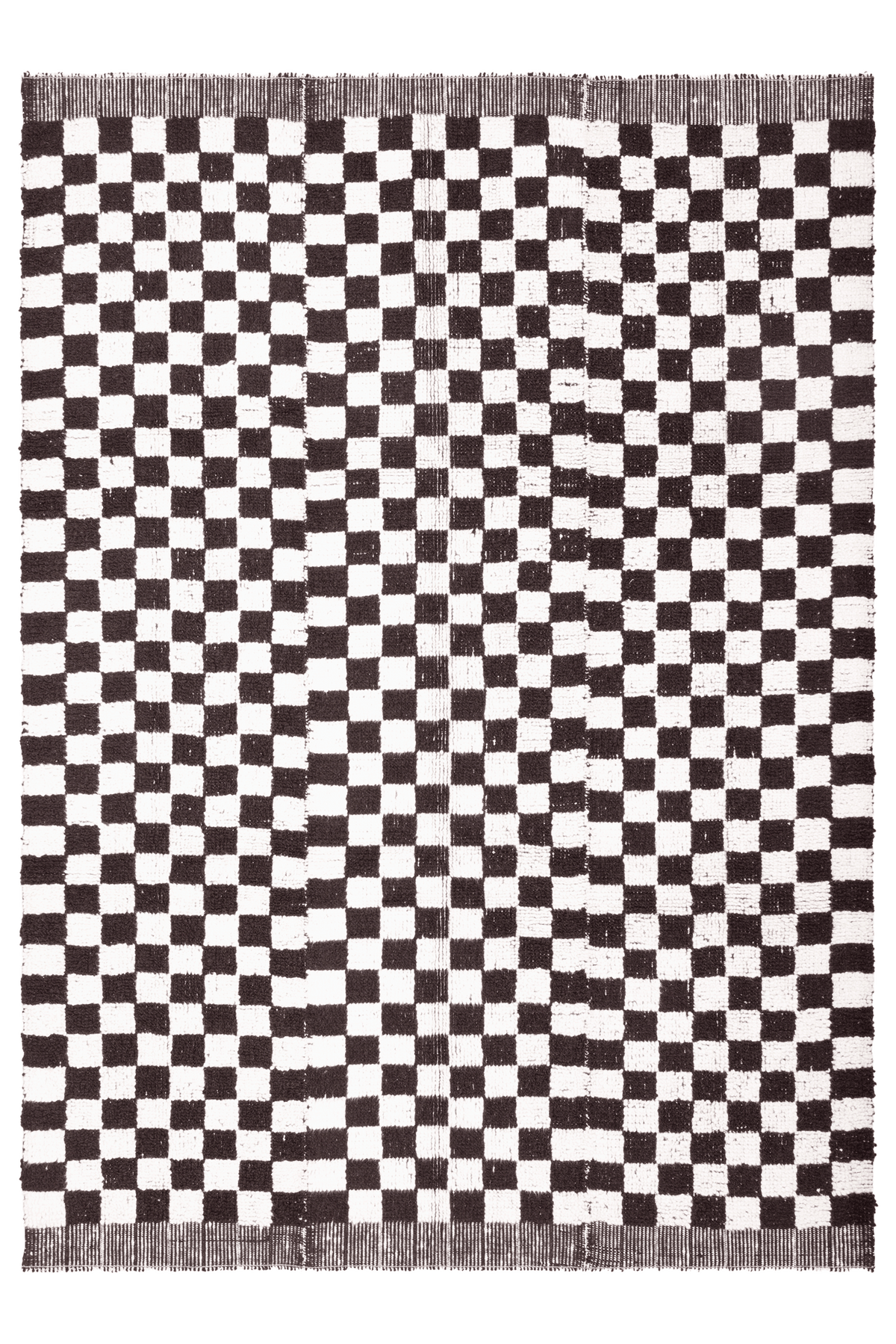 Handwoven black and white checkered shaggy wool rug with a thick, soft pile and durable cotton blend construction.
