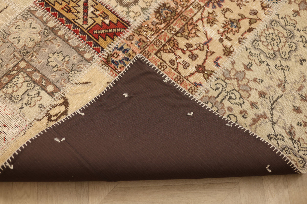 Handmade 5x7 patchwork Turkish rug with floral patterns, wool and cotton blend, showing a brown fabric backing.