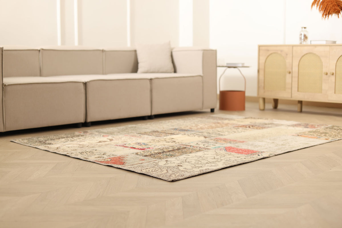 5x7 ft vintage Turkish patchwork area rug with floral patterns in wool and cotton on a light wood floor.