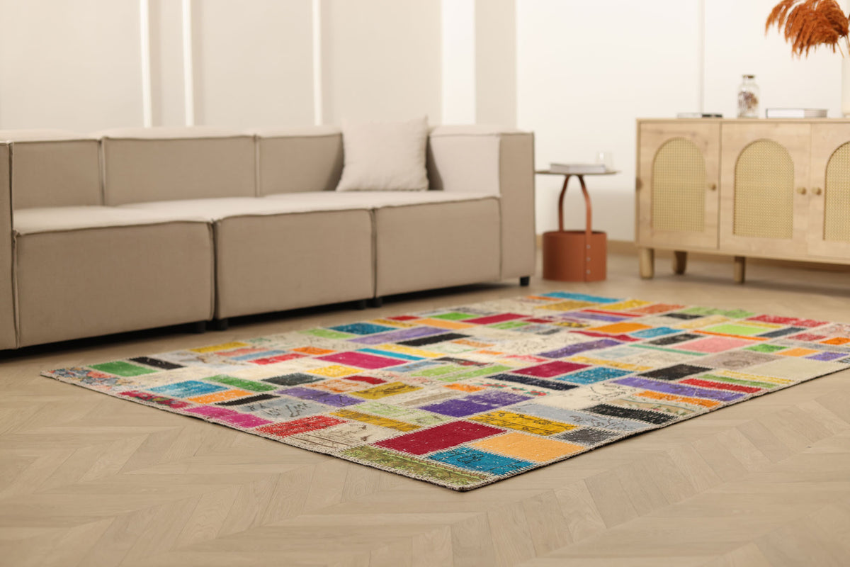 5x8 ft handmade Turkish patchwork area rug with vibrant, multi-colored floral patterns in wool and cotton.
