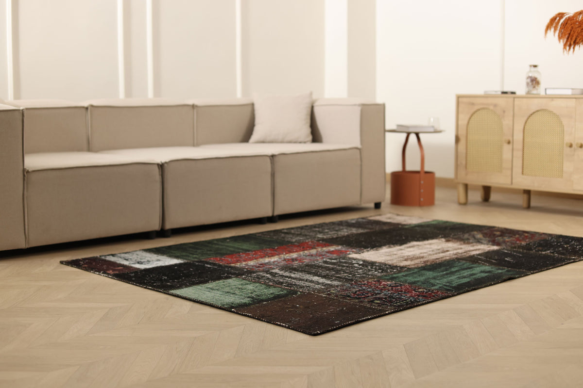 5x7 ft black patchwork vintage Turkish rug with distressed wool and cotton patterns in a modern living room.