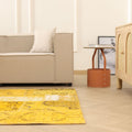 Vintage yellow patchwork Turkish area rug in wool and cotton, featuring an overdyed bohemian design in a modern living room.