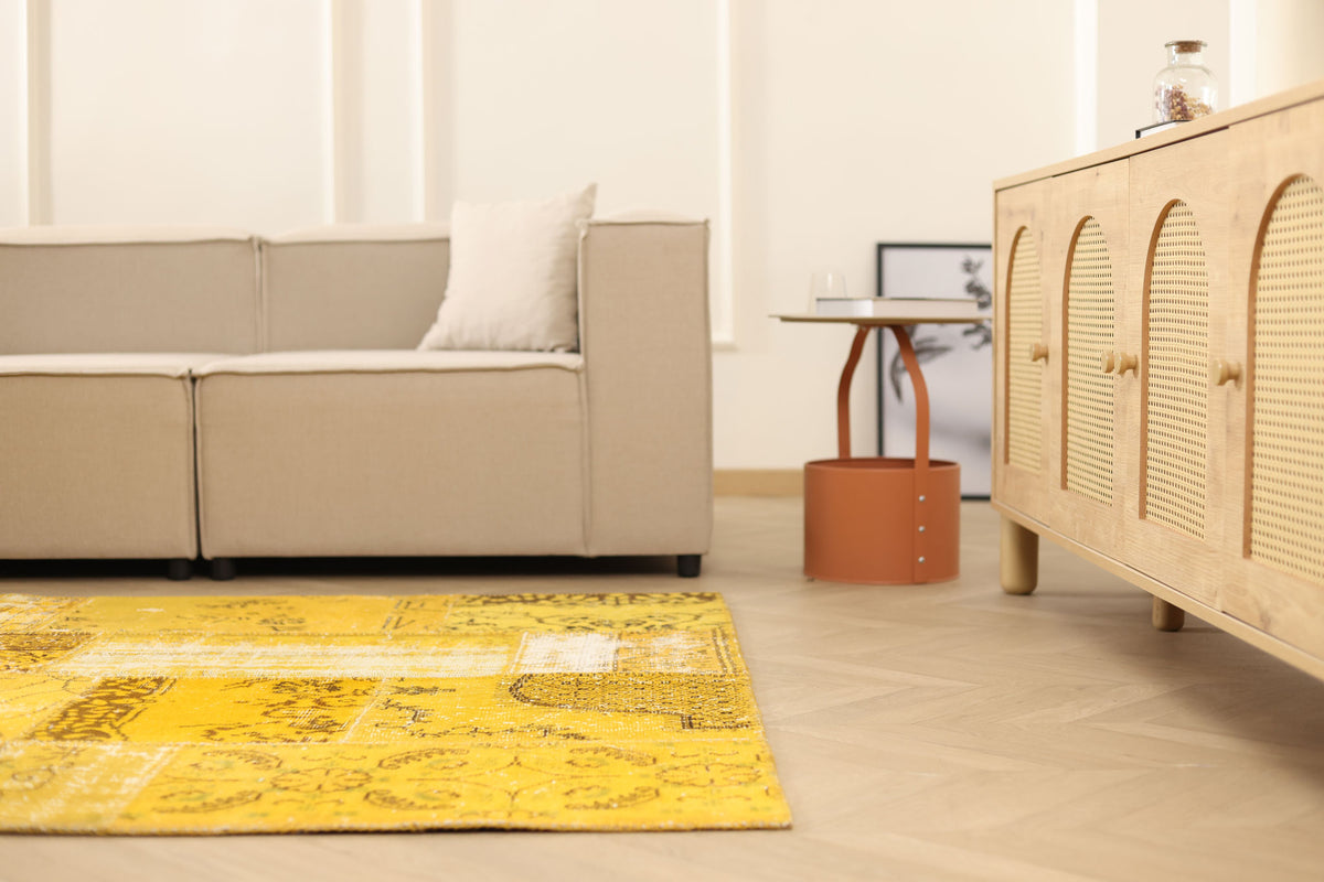 Vintage yellow patchwork Turkish area rug in wool and cotton, featuring an overdyed bohemian design in a modern living room.