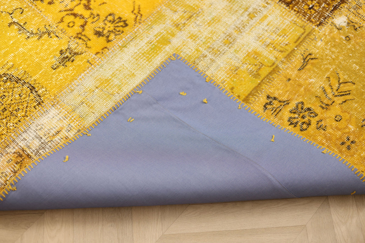 Vintage yellow patchwork Turkish area rug with a blue fabric backing and hand-stitched wool and cotton details.