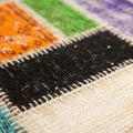 Handmade Turkish patchwork rug with vibrant wool and cotton fabric squares in a bohemian floral design.