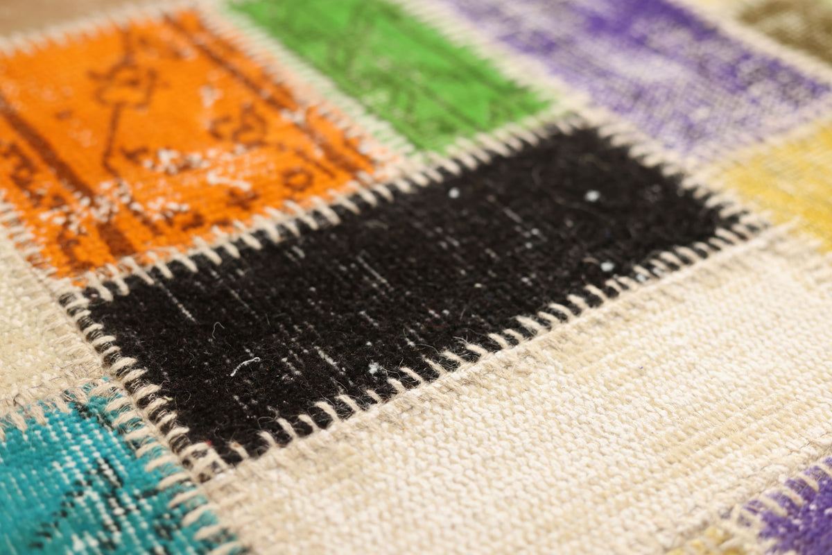 Handmade Turkish patchwork rug with vibrant wool and cotton fabric squares in a bohemian floral design.