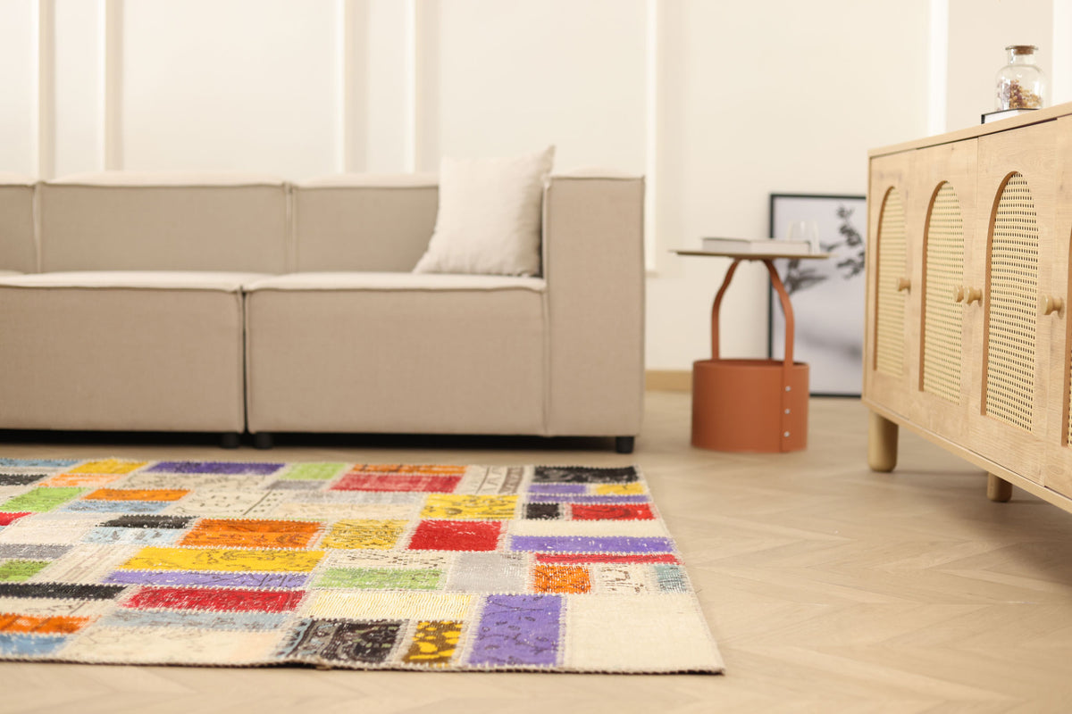 Handmade 5x8 ft vintage Turkish patchwork rug with vibrant, multicolored floral patterns in wool and cotton.