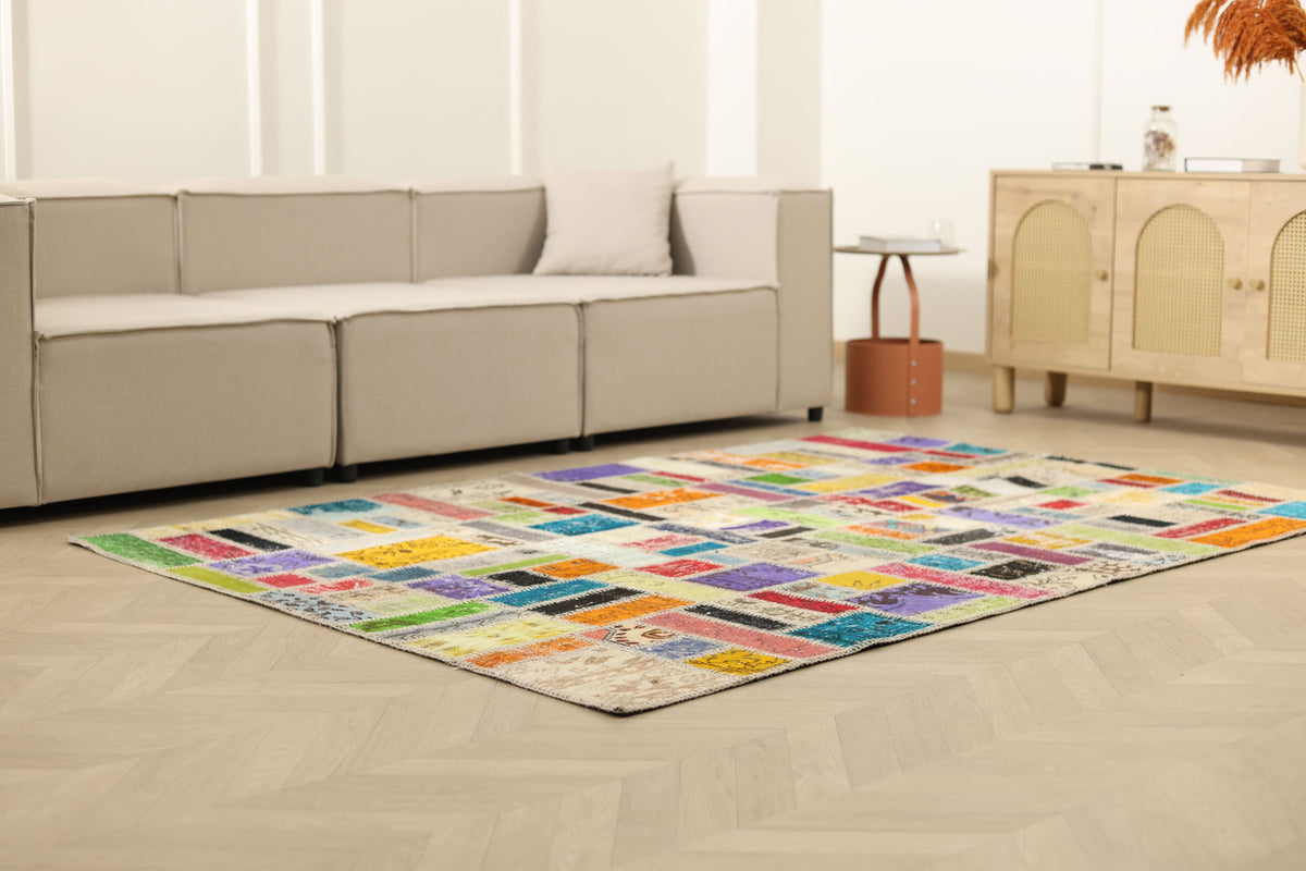 5x8 ft handmade patchwork Turkish area rug featuring vibrant multi-colored floral patterns in wool and cotton.