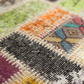 Handmade vintage Turkish patchwork rug featuring colorful, hand-stitched wool and cotton floral patterns in a bohemian style.