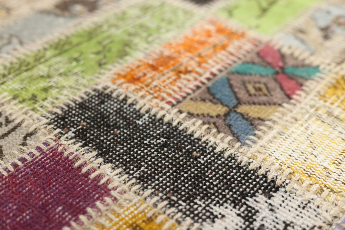 Handmade vintage Turkish patchwork rug featuring colorful, hand-stitched wool and cotton floral patterns in a bohemian style.