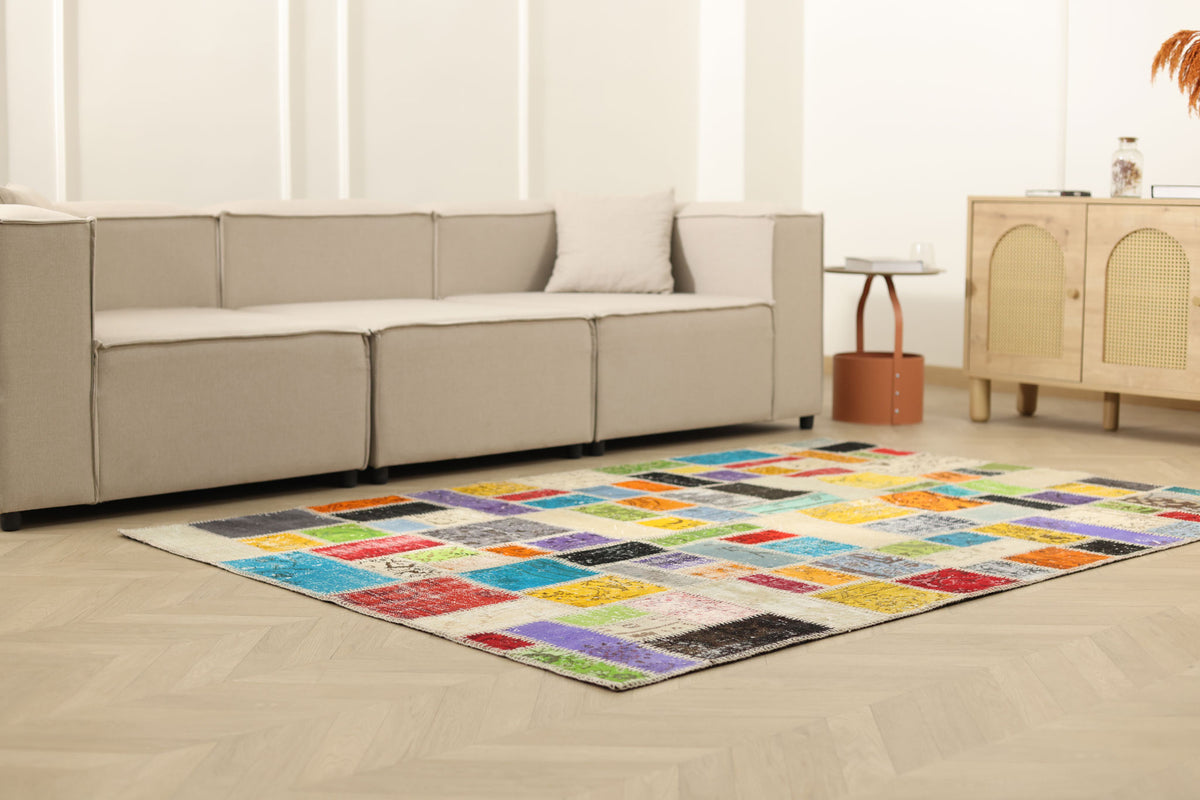 Handmade 5x7 ft patchwork Turkish area rug featuring vibrant, multi-colored floral patterns in wool and cotton.