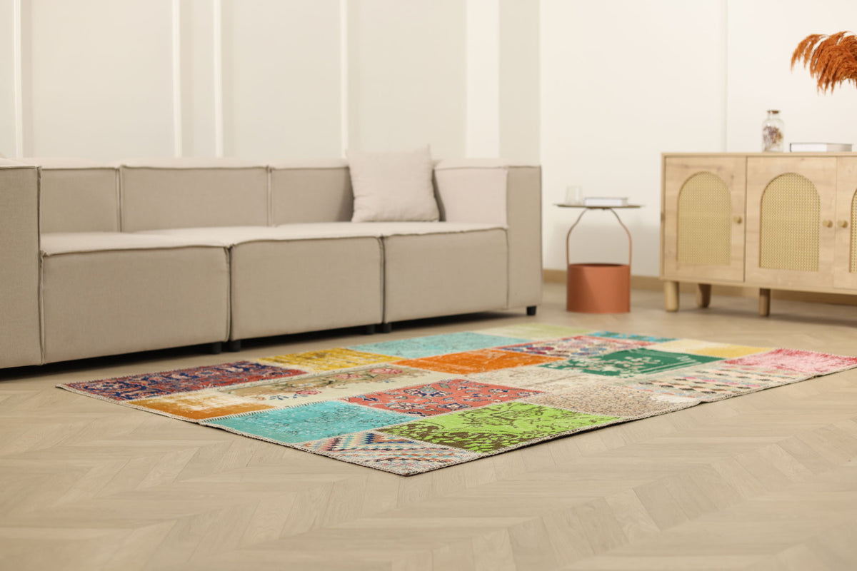 5x7 ft handmade Turkish patchwork area rug in vibrant floral patterns, crafted from wool and cotton in a bohemian style.