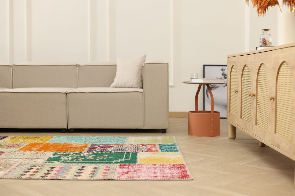 5x7 ft handmade patchwork Turkish area rug with vibrant floral patterns in wool and cotton, styled in a modern living room.
