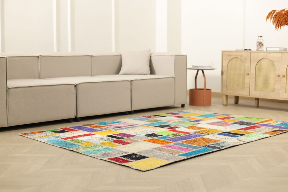 Handmade 5x7 ft vintage Turkish patchwork area rug featuring vibrant geometric patterns in wool and cotton.