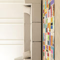 Handmade 5x7 ft vintage Turkish patchwork rug with vibrant geometric patterns in wool and cotton next to a beige sofa.
