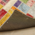 Handmade 5x7 patchwork Turkish rug with vibrant geometric wool and cotton squares and a dark fabric backing.
