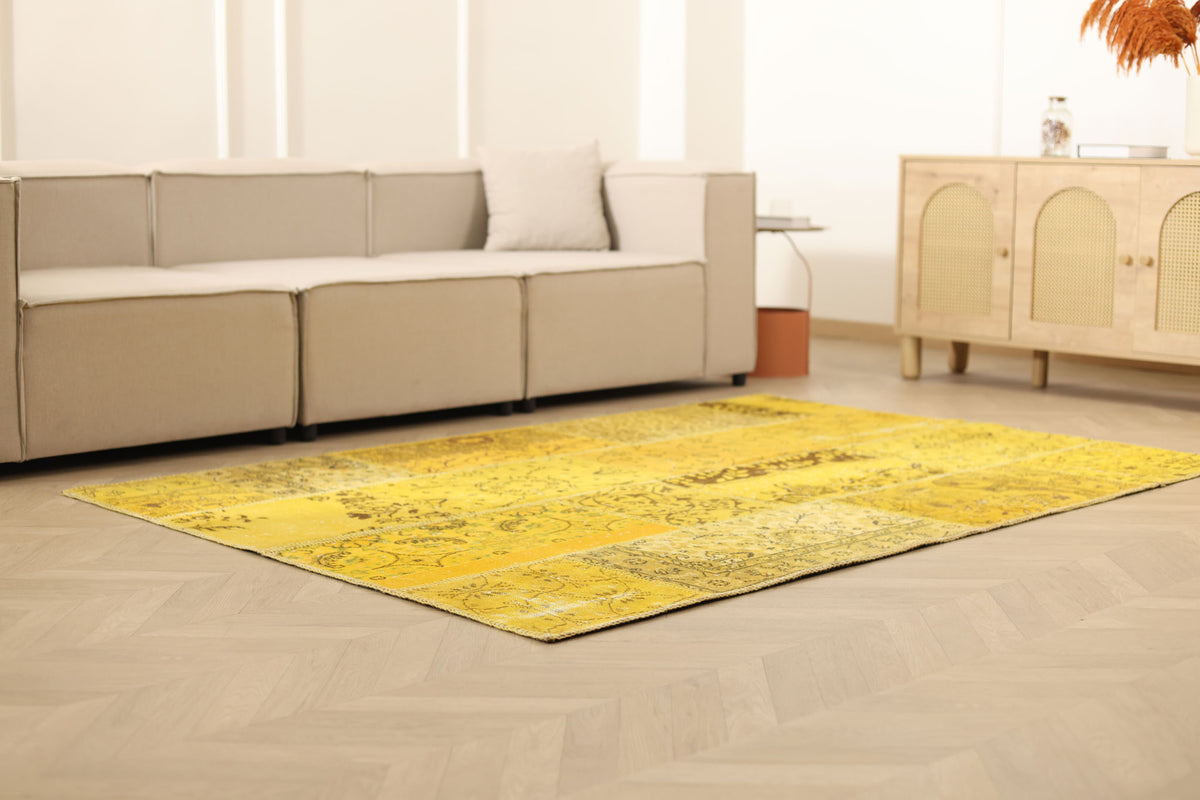 5x7 ft yellow patchwork vintage Turkish area rug with overdyed patterns in a bohemian living room setting.
