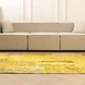 Yellow vintage Turkish patchwork area rug with overdyed patterns and bohemian style in a modern living room setting.
