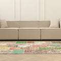 5x7 ft vintage Turkish patchwork area rug with vibrant floral patterns in wool and cotton, set before a beige sofa.