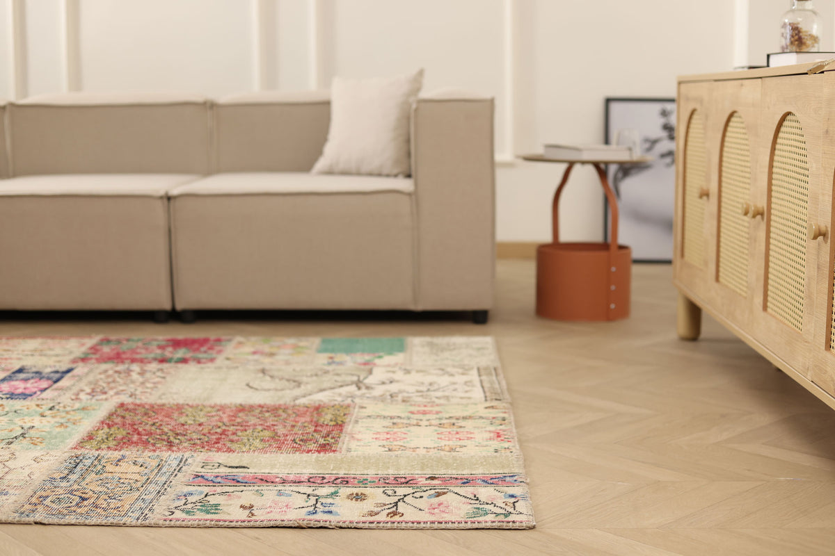 Handmade 5x7 ft vintage Turkish patchwork area rug with vibrant floral patterns in wool and cotton on a wooden floor.