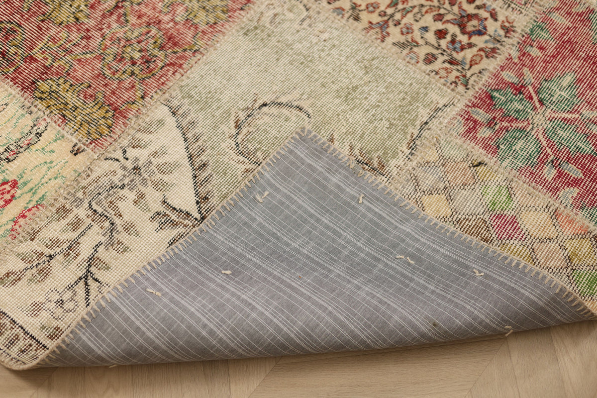 Handmade 5x7 ft patchwork Turkish rug with vibrant floral patterns, wool and cotton blend, showing the stitched fabric backing.
