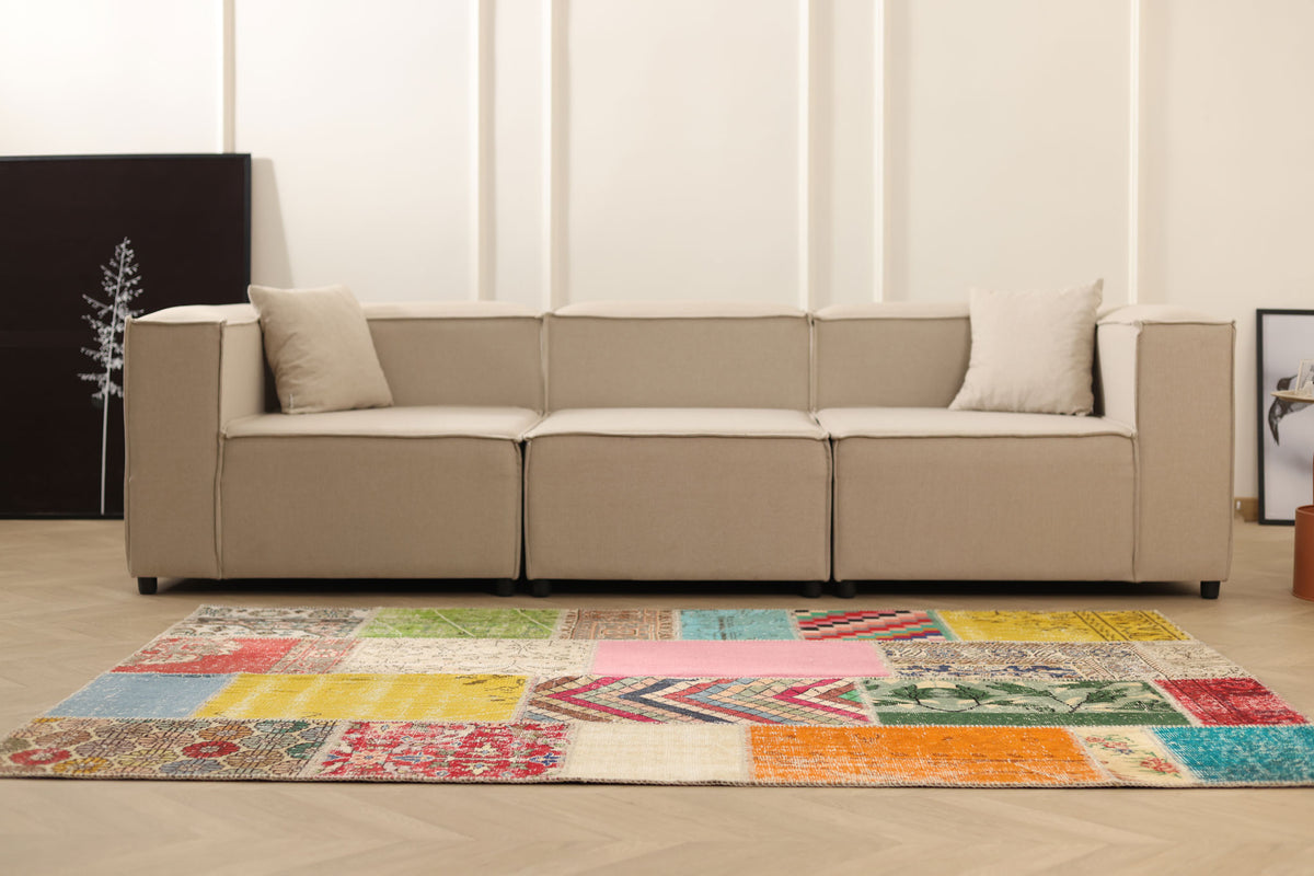5x7 ft handmade Turkish patchwork area rug with vibrant geometric patterns in wool and cotton, styled in a modern living room.