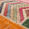 Handmade 5x7 ft vintage Turkish patchwork rug featuring colorful geometric patterns in wool and cotton.