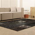 5x7 ft black distressed patchwork Turkish wool and cotton area rug in a modern bohemian living room.