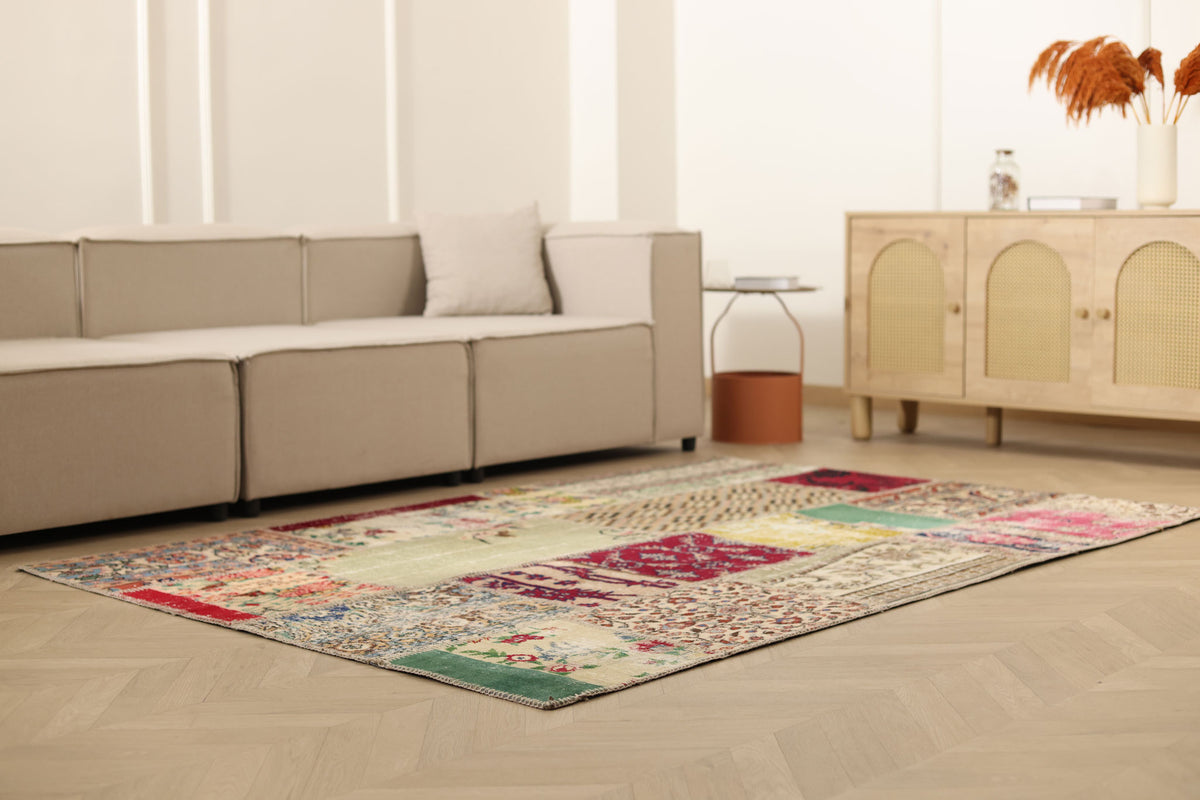 5x7 ft vintage Turkish patchwork area rug with vibrant floral patterns, hand-stitched wool and cotton in a bohemian living room.
