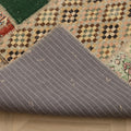 Handmade 5x7 ft vintage Turkish patchwork rug featuring colorful floral patterns and a grey striped fabric backing.