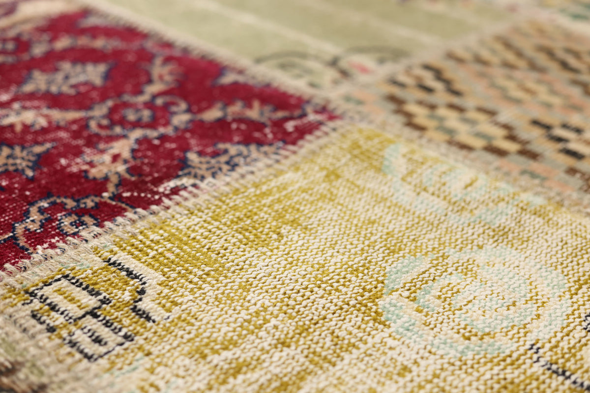 Handmade vintage Turkish patchwork rug featuring vibrant floral patterns in wool and cotton with a textured, eclectic design.