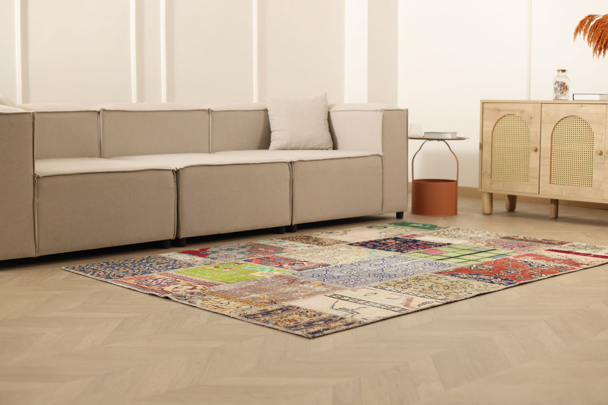 5x7 ft handmade Turkish patchwork area rug featuring vibrant floral patterns in wool and cotton on a light wood floor.