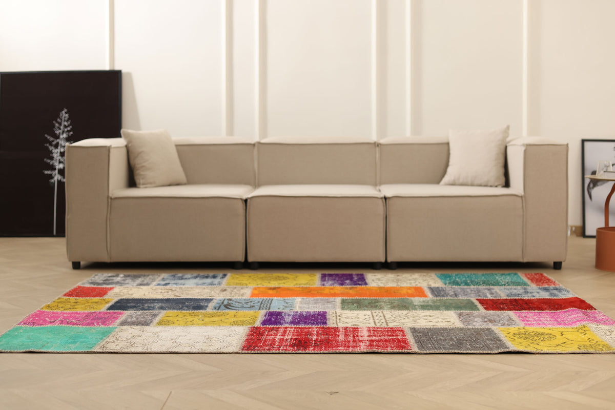 Handmade 5x7 ft Turkish patchwork area rug featuring vibrant, multi-colored floral patterns in wool and cotton.