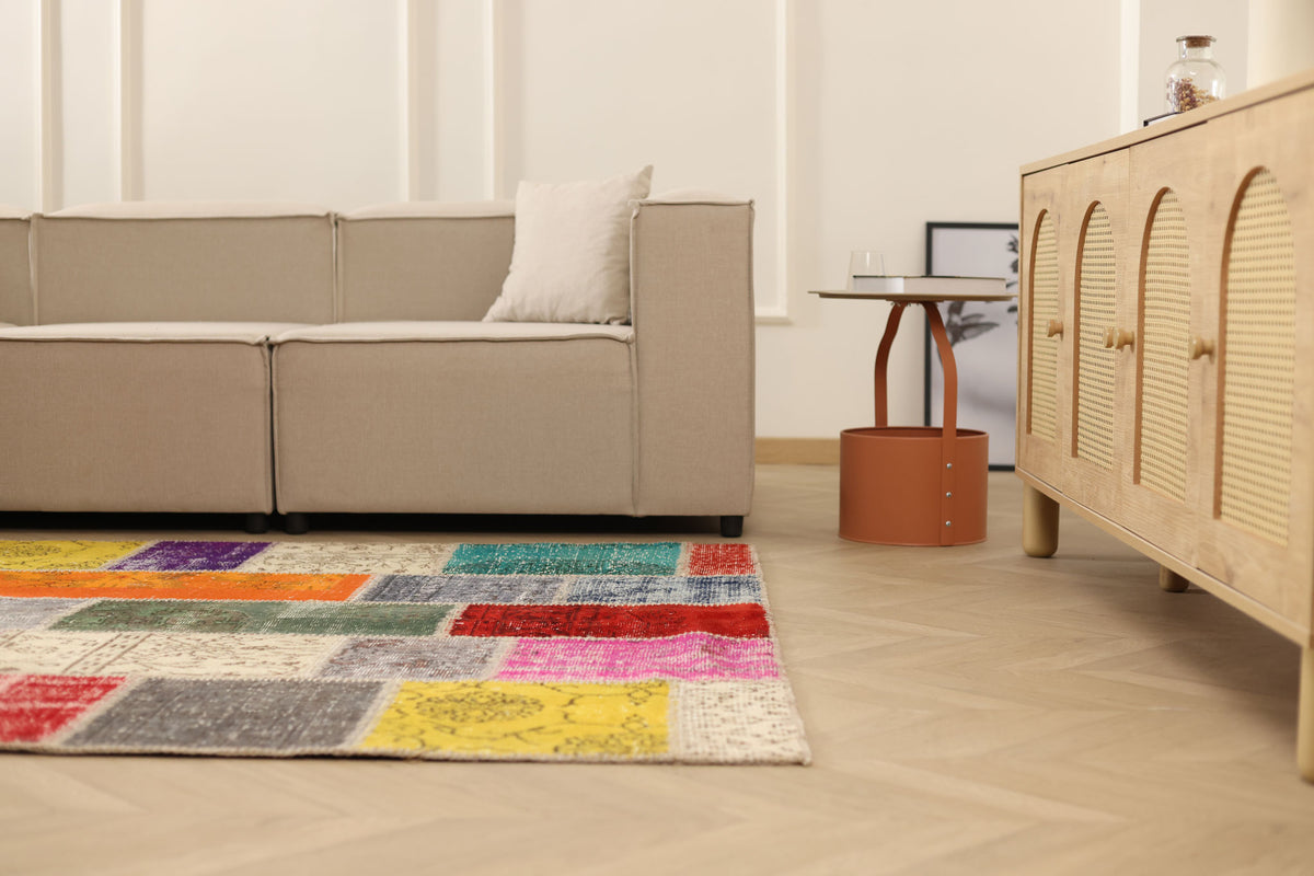Multicolor patchwork vintage Turkish rug in wool and cotton, featuring vibrant floral patterns in a bohemian living room.