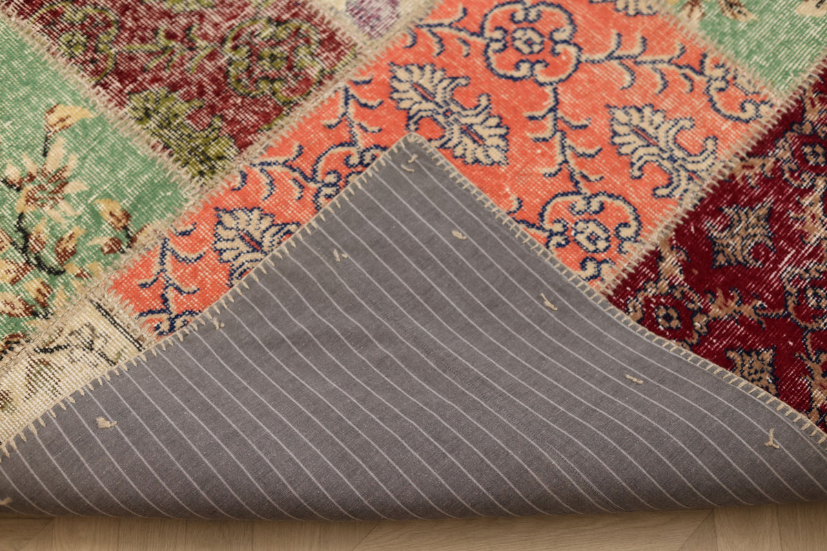 Vintage Turkish patchwork area rug with colorful floral patterns, wool and cotton construction, and a grey striped backing.