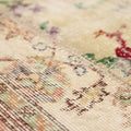 Close-up of a vintage Turkish patchwork area rug featuring hand-stitched floral patterns in vibrant wool and cotton.