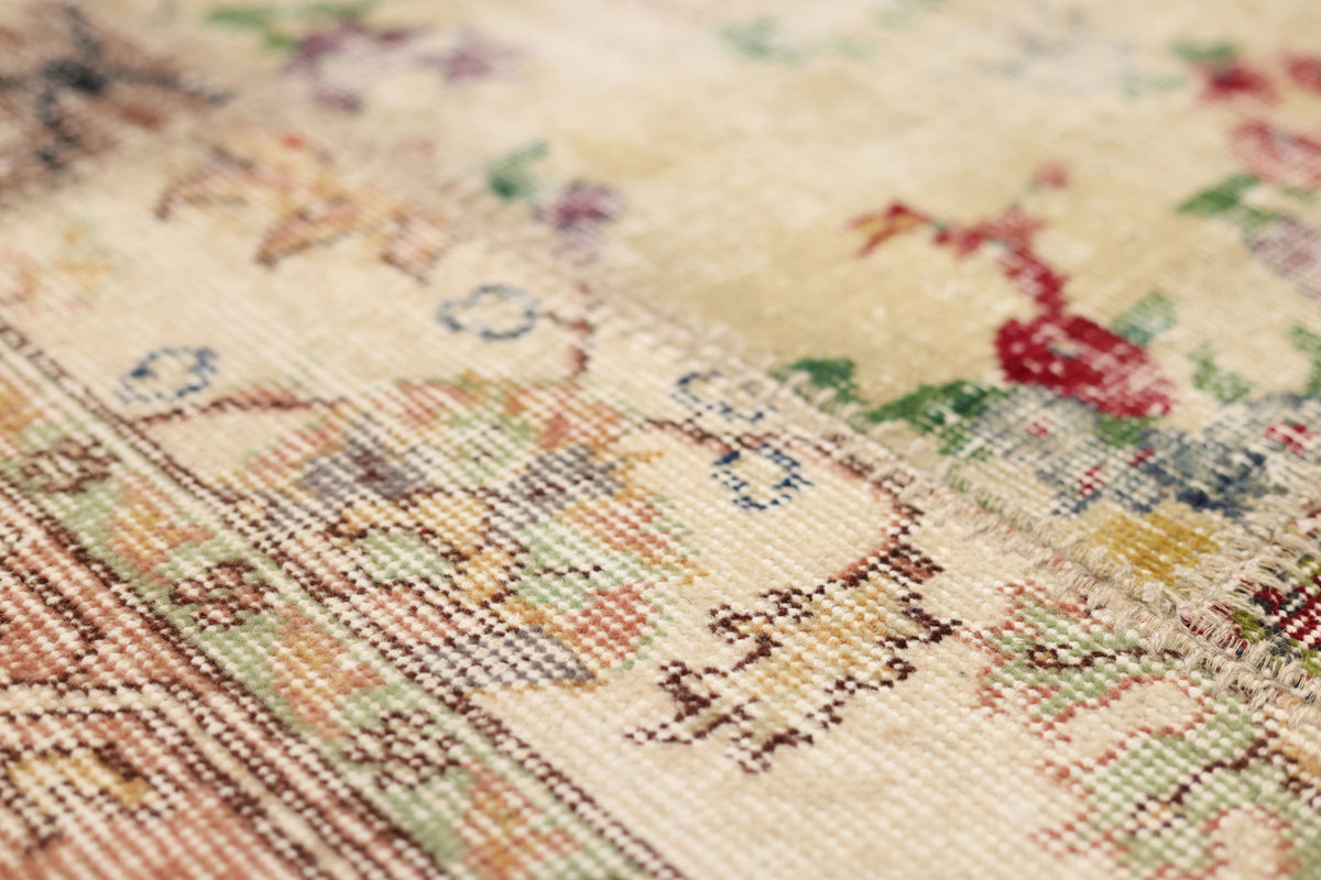 Close-up of a vintage Turkish patchwork area rug featuring hand-stitched floral patterns in vibrant wool and cotton.