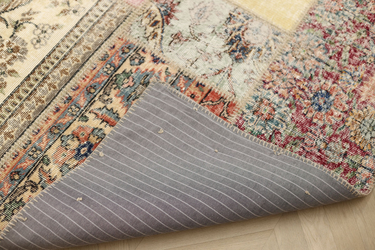 Handmade 5x7 patchwork Turkish rug with vibrant floral wool patterns and a grey striped cotton backing.