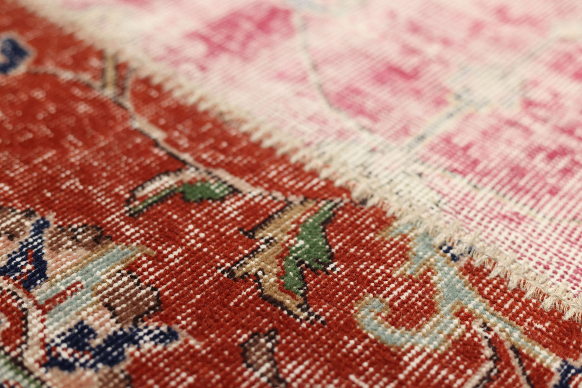 Handmade Turkish patchwork area rug featuring vibrant red and pink floral wool patterns with visible hand-stitched details.