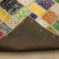 Handmade 6x6 ft patchwork Turkish area rug with vibrant geometric wool and cotton squares and a dark fabric backing.