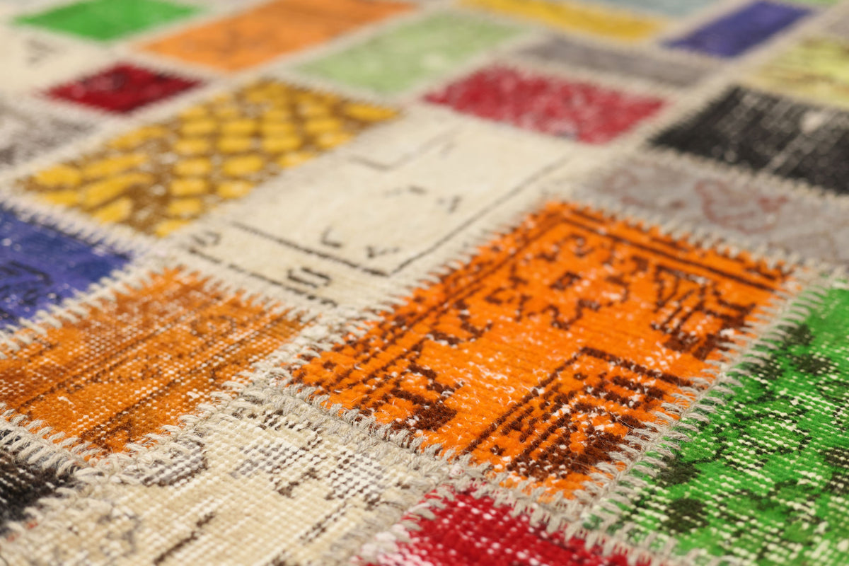 Handmade vintage Turkish patchwork area rug featuring vibrant geometric patterns in wool and cotton.
