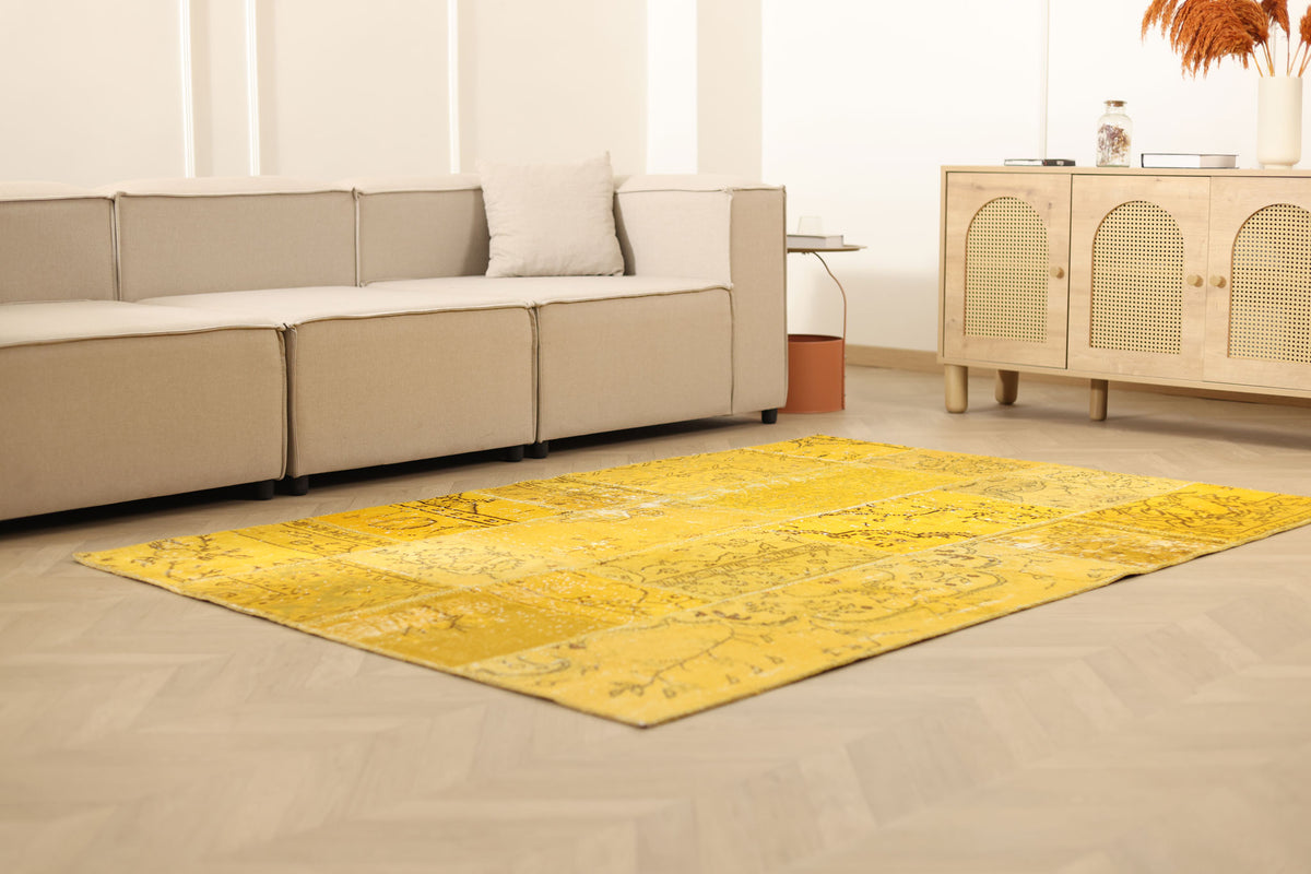 5x7 ft yellow patchwork Turkish area rug in wool and cotton with vintage overdyed patterns in a bohemian living room.