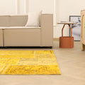 5x7 ft yellow patchwork Turkish area rug in wool and cotton with vintage overdyed patterns in a bohemian living room.