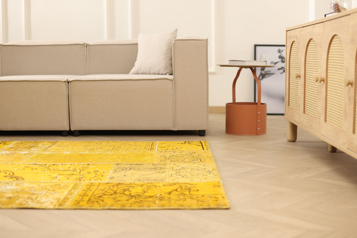 5x7 ft yellow patchwork Turkish area rug in wool and cotton with vintage overdyed patterns in a bohemian living room.