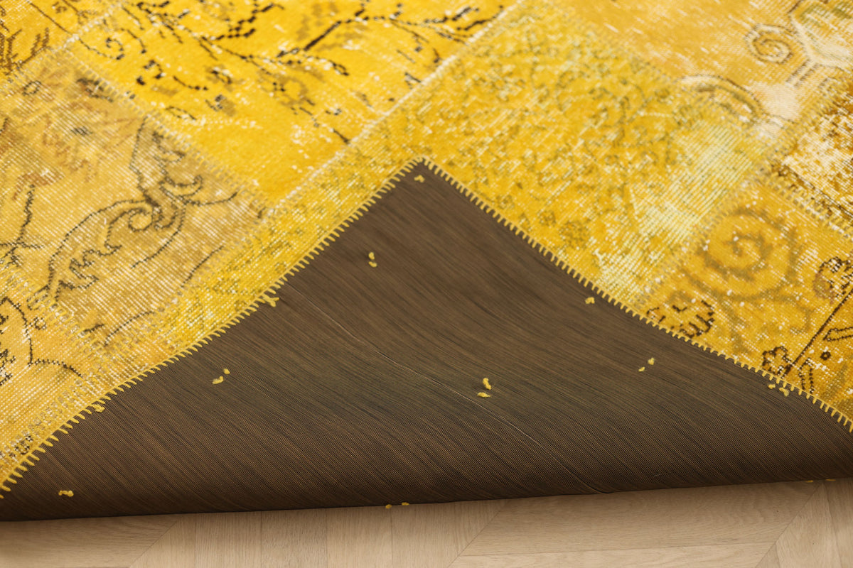 Yellow vintage Turkish patchwork area rug with wool and cotton construction and a protective fabric backing.