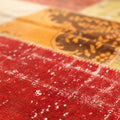 Handmade vintage Turkish patchwork rug in vibrant red and yellow wool with overdyed bohemian patterns.