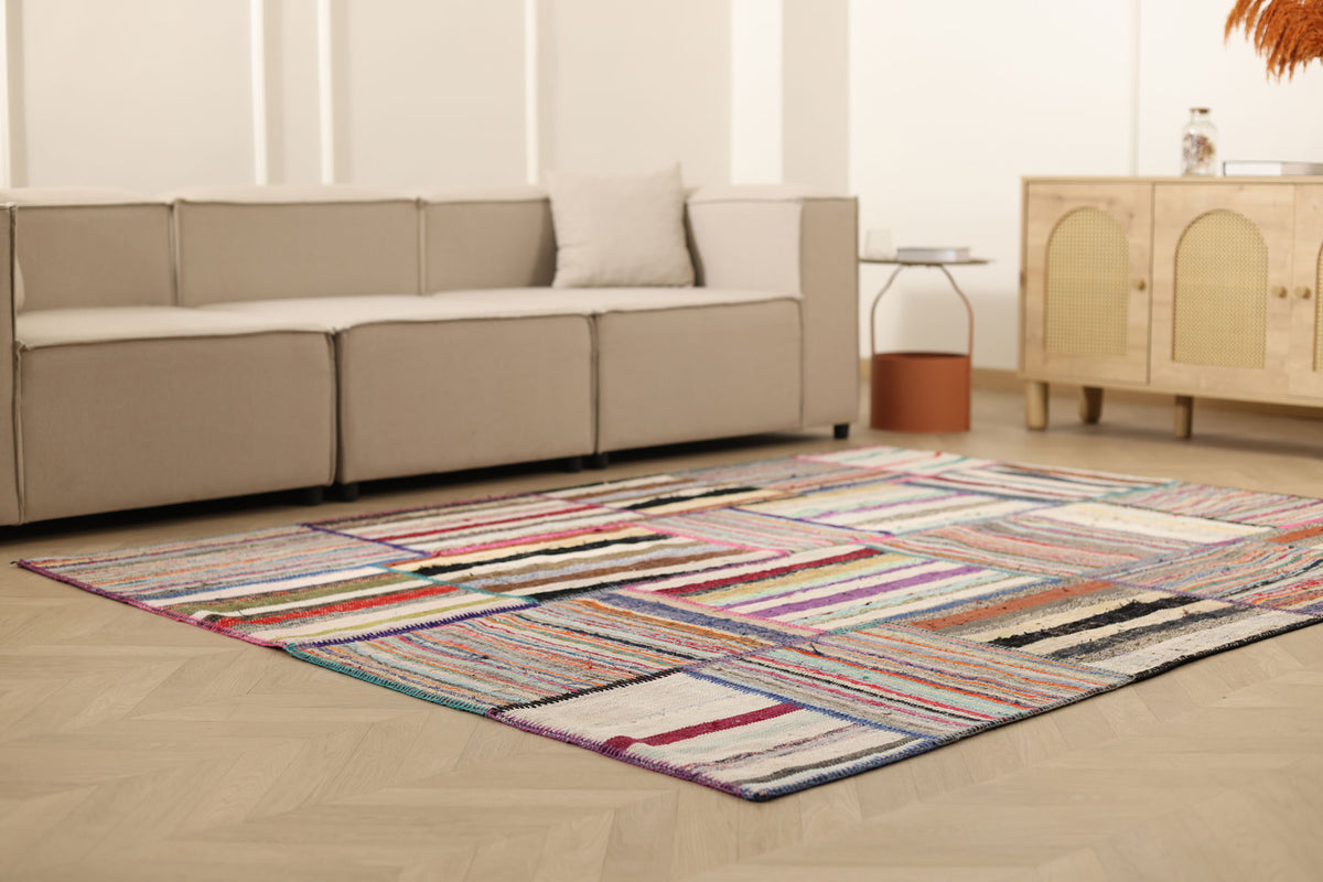 Handmade 6x8 ft vintage Turkish patchwork area rug featuring vibrant multicolored striped patterns in wool and cotton.
